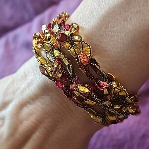 Bright red & gold 7" hamdmade beaded bracelet laced with shimmery ribbons.